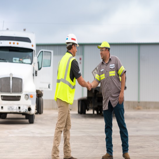 Aaron Booth shaking hands with a worker