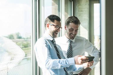 Two young businessmen looking at documents