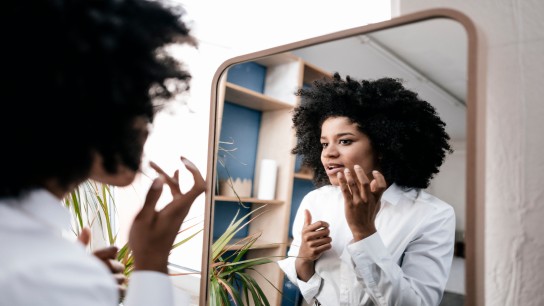 Young woman applying lip care